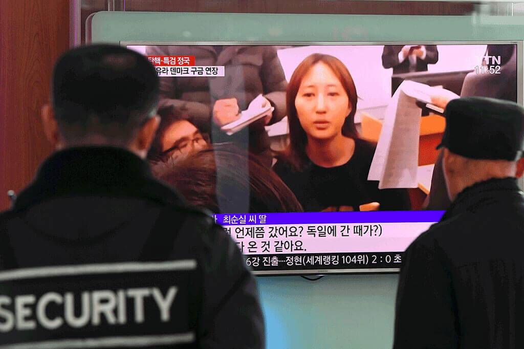 People watching TV news broadcast at a railway station in Seoul on Jan 3, 2017, on the arrest of Ms Chung.